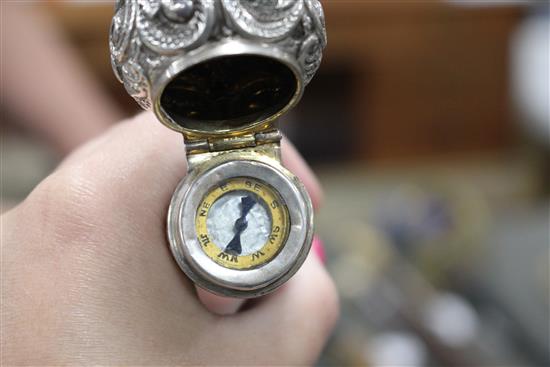 A Victorian walking stick with embossed silver pommel H.M., Birmingham 1906, opens to reveal a compass, overall length 89.5cm